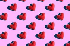 several red heart shaped objects are on a pink and blue background with small hearts in the middle