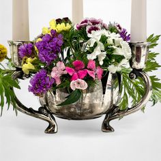 a silver vase filled with lots of different colored flowers