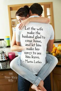 a man and woman sitting on top of each other in front of a kitchen counter