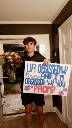 a young man holding up a sign that says, ur obesew and i'm obsesed with you prom