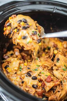 a spoonful of mexican chicken casserole being lifted from the slow cooker