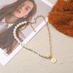 Adorn your ensembles with the elegant shine of this necklace boasting a half-chain, half-pearl look. Chain : 18.15" L with 1.96" extender Pendant : 0.79" diameter Lobster claw clasp 18k gold-plated copper / pearl White Round Necklace With Gold Chain, White Necklace With Gold Chain, Gold Pearl Choker With Clavicle Chain, Gold Pearl Clavicle Chain Choker, Gift Pearl Choker With Chain Detail, Gift Pearl Chain Choker Necklace, Pearl Chain Necklace With Round Pearl Charm, Pearl Chain Necklace With Pearl Charm, Pearl Choker Necklace With Chain As Gift