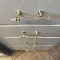 the handles on this refrigerator are made out of glass and brass fittings to match the cabinet doors