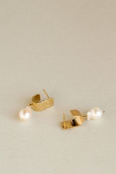 A comfortable yet unexpected everyday stud earring. A single baroque pearl is suspended from a stately ear cuff, cast from antique decorative sheeting. The cuff features an intricate stamp pattern of diamonds, contrasting with the lustrous and organic simplicity of the pearl: a natural harmony of two forms. This style finds its origins in our Maretta earrings. Pictured here with the Sunrise Studs. Materials Gold vermeil earring with baroque pearl. The metals we use are recycled. Click here to ex Classic Metal Earrings With Pearl Charm, Classic Hammered Earrings For Formal Occasions, Luxury Pearl Earrings With Pearl Charm, Classic Metal Pearl Earrings With Pearl Charm, Elegant Metal Jewelry With Pearl Pendant, Elegant Gold Plated Silver Ear Cuff, Elegant Yellow Gold Brass Ear Cuff, Elegant Hammered Earrings For Wedding, Elegant Hammered Wedding Earrings