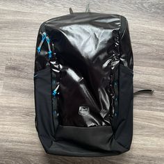 a black backpack sitting on top of a wooden floor