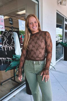 Sheer, lace, long-sleeve top. This edgy and feminine shirt is perfect for layering throughout the seasons. Wear on its own with a tank top or bandeau underneath. Made from a soft and stretchy material that is extremely lightweight. Features thumb holes for an urban inspired look. Outfit inspo: Great to wear under a graphic tee or dress, casually, or to a concert or festival. Ella-Morgan is seen wearing a size medium. 90% nylon, 10% spandex. Feminine Shirts, The Seasons, Thumb Holes, Sweater Coats, Sheer Lace, Tee Shop, Skirt Pants, Stretchy Material, Long Tops