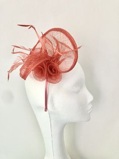 A striking coral coloured Sinamay fascinator, the perfect accessory to a summer outfit! Crafted from gorgeous coral Sinamay, central rosebuds and finished with delicate feathers in the same colour is a striking addition to any outfit! This piece sits comfortably on the head with a coral satin covered headband, if you would prefer a comb please just add a note at checkout.  Fascinator measures 19cm x 16cm Our timeless pieces are perfect for any special occasion from Weddings to The Kentucky Derby and Summer Garden Parties! We offer ready to wear pieces in a variety of styles and colour! However if you want to make your piece unique, we can customise any piece with additional feathers and make it your own! Similarly most fascinators can be created on a comb, headband or clip, whichever you w Orange Headpiece For Kentucky Derby Races, Orange Headpieces For Kentucky Derby Races, Elegant Orange Fascinator For Wedding, Orange Mini Hat For Kentucky Derby Races, Orange Mini Hat For Kentucky Derby, Orange Adjustable Mini Hats For Wedding, Wedding Mini Hat In Orange With Adjustable Fit, Adjustable Orange Mini Hats For Weddings, Adjustable Orange Mini Hat For Wedding