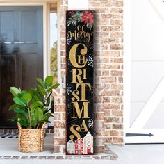 a sign that says merry christmas on it next to a potted plant in front of a door