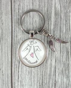 a keychain with an angel holding a heart on it's side and the words i love you