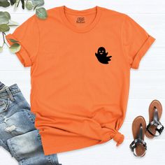 Cute Ghost Shirt, Pocket Funny Halloween Shirt, Womens Halloween Shirt, Fall Graphic Tee, Halloween outfit, Pumpkin Shirt, Сute Little Ghost. Get into the spooky spirit with our Halloween shirts collection! Perfect for any Halloween occasion, our range includes "Halloween T-Shirts" and unique "Halloween Gifts." Stand out with a "Cute Ghost Shirt" or classic "Ghost Shirt." Ready for a party? Try our "Halloween Party" shirts or "Halloween Ghost Tees." Coordinate with friends with "Halloween Group Casual Orange Tops For Halloween, Spooky Orange Crew Neck Top, Orange Crew Neck Top For Halloween, Orange Cotton Tops For Halloween, Casual Cotton Halloween Shirt, Casual Crew Neck Shirt For Halloween, Fun Halloween Short Sleeve Shirt, Halloween Novelty Cotton Shirt, Casual Short Sleeve Shirt For Halloween