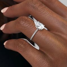 a woman's hand with an engagement ring on her finger and diamond band around it