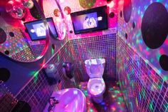 a bathroom that has some lights on the walls and in the floor, it is decorated with polka dots