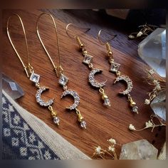 Listing is for ONE (1) pair of earrings.  These beautiful crescent moon earrings are crafted with gold plated pyrite beads, gold plated crystal moon charms, glass diamond shaped charms, Czech faceted glass beads, & matching hoops + your preference of hook style. ▪︎▪︎▪︎▪︎▪︎ * (Quantity: ONE (1) pair each - Though others may be recreated similarly, it may take longer depending on supply inventory, please contact me.) * Please note that as each product is handmade, each one will be unique and one o Mystical Gold Moon Phase Earrings, Mystical Gold Jewelry With Matching Earrings, Gold Crescent Earrings With Moon Phase Detail, Gold Dangle Earrings With Moon Phase Detail, Celestial Moon Charm Crystal Earrings, Gold Celestial Crystal Earrings Nickel Free, Gold Celestial Crystal Earrings Nickel-free, Mystical Gold Earrings With Moon Charm, Gold Celestial Crystal Earrings For Pierced Ears