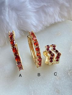 "These red CZ Hoop and Huggie Earrings are 18K Gold Filled. There are three styles available with a lever back closure: A. This is a medium sized hoop with oval reddish CZ stone. The stone color is more true to a fire brick red. dimension: 19mm x 19mm (approximately 3/4\")   B. A medium sized hoop with a round \"brick red\" CZ stone. Diameter: 18mm C. Huggie are a small hoop that hugs the ear lobe when you wear it. This Huggie earring comes with dark red CZ stone. it measures approximately .5\" in diameter and .5\" in height.  Hypoallergenic Nickel Free Water & Sweat Resistant  18K Gold Filled / Oro Laminado 18K" Elegant Red Huggie Hoop Earrings, Red Hoop Jewelry For Anniversary, Red Small Hoop Jewelry For Anniversary, Elegant Small Red Hoop Earrings, Elegant Red Small Hoop Earrings, Red Huggie Earrings For Anniversary, Red Ruby Hoop Earrings, Small Red Hypoallergenic Hoop Earrings, Red Adjustable Hypoallergenic Hoop Earrings