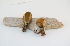 two wooden spoons sitting on top of a piece of driftwood next to each other