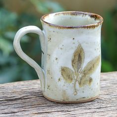 a white coffee cup sitting on top of a wooden table