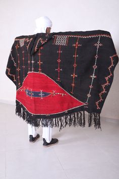 "Authentic moroccan black cape Please see last images for more details on the dimensions 229 CM X 111 CM = 90.1 INCHES X 43.7 INCHES Akhnif is the name for the shepherd's cloak as it was worn in south western morocco by jewish and berber men and boys. The akhnif cape was woven in one piece on an upright loom. from goat's hair or wool. Typical for this black mens burnous is bright red \" half moon \" on the back. visible from great distance, The richly embroidered decoration made an akhnif of thi Traditional Black Shawl Outerwear, Traditional Long Sleeve Poncho, Black Bohemian Cape For Festivals, Bohemian Black Cape For Festival, Traditional Black Cape For Festival, Traditional Black Festival Cape, Traditional Black Ceremonial Outerwear, Traditional Shawl Outerwear, Berber Clothing