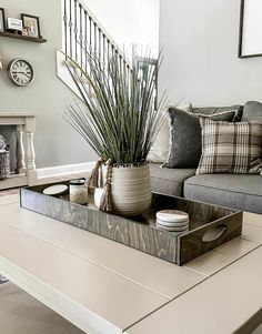 a living room with a couch, coffee table and clock on the wall behind it