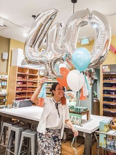 a woman is holding up balloons in the shape of the number forty and it's 40