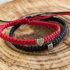 "Celebrate your unique bond with these beautifully crafted Couple Bracelets. Perfect for anniversaries, special occasions, or just as a token of your love. Features: Adjustable Fit: Both bracelets are adjustable. The red one can close up to almost 6\", while the black one adjusts to nearly 6.5\", ensuring a snug fit for most wrist sizes. Personalized Initials: Add a personal touch with engraved initials. The red color bracelet showcases your chosen initial, while the black bracelet features a st Valentine's Day Friendship Name Bracelet, Adjustable Red Bracelets For Anniversary, Couples Jewelry For Valentine's Day Anniversary, Valentine's Day Black Heart Charm Bracelet, Heart Charm Jewelry For Couples, Black Heart Bracelet With Heart Charm, Personalized Black Heart Bracelet Adjustable, Couples Jewelry With Heart Charm For Gift, Adjustable Black Bracelets For Valentine's Day