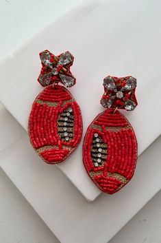 Color: Red Style: Dangle Football Shaped Beaded Detail Rhinestone Detail Gold Threaded Trim Felt Backing 2.5" Drop Launched: Red Embellished Party Jewelry, Red Party Beaded Earrings With Colorful Beads, Rhinestone Football, Football Earrings, Football Fashion, Fashion Beads, Earrings Red, Red Style, Gold Threads