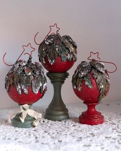 three red ornaments sitting on top of a white table