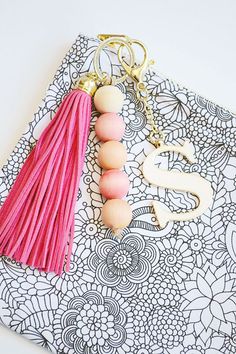 a tasseled keychain with a pink tassel hanging from it's side