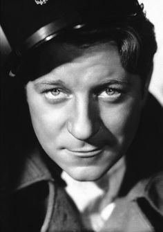 black and white photo of man in uniform with pilot's cap on his head