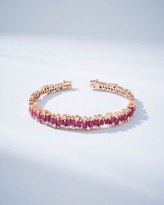 The Shimmer Audrey Ruby Bangle is the epitome of sophistication and refined style. It is exquisitely handcrafted with 18-karat spring gold wire to ensure both comfort and flexibility. Set with 4.00 carats of striking ruby baguettes and accented with 0.42 carats of glistening round white diamonds, this bangle makes a profound statement of luxury. Whether it graces your wrist alone or is paired with other bracelets, its beauty is guaranteed to elevate your look. Details 18k rose gold 4.00 carats o Ruby Bangles, Bangles Making, Refined Style, Gold Wire, White Diamonds, 18k Rose Gold, Diamond White, Ruby, Bangles