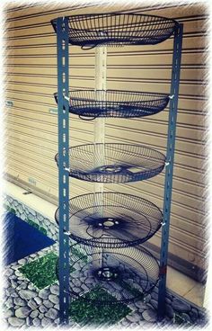 three tiered metal rack with wheels on top