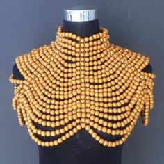 This beautiful necklace is available in different colours such as Black, white, red, Brown, yellow, green, Orange and Gold. Please note that the Cleopatra is available in the following neck sizes: 13 inches (33 cm) 14 inches (36 cm) 15 inches (38 cm) The necklace comes with a matching bangle. Gold Necklaces With Wooden Beads For Festivals, Bohemian Wooden Beads Jewelry For Party, Unique Yellow Choker Necklace, Gold Bib Necklace With Colorful Beads, Elegant Party Necklace With Wooden Beads, Yellow Choker Necklace For Festivals, Large Round Beads Choker, Bohemian Gold Beads Bib Necklace, Festival Gold Beads Choker Necklace