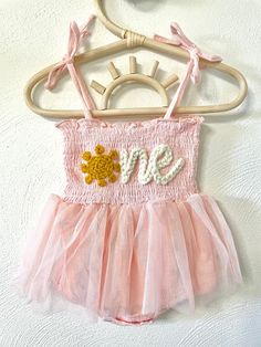 Our custom hand embroidered name tutus are sure to look adorable on the sweet little one in your life!  Give them as gifts for baby showers, name announcements, first birthday's, Xmas gifts, and more!  These tutu's are also perfect to wear for your little one's first birthday!  Just pick out the color tutu and yarn you want and leave the rest up to us!  Your little girl will look absolutely adorable in her StitchedxStacey custom tutu! Choose the color of your tutu romper in the above drop down. Whimsical Summer Tutu Dress For Playtime, Summer Baptism Tutu Dress With Floral Applique, Princess Tutu Dress With Floral Applique For Birthday, Cute Floral Applique Dress For Birthday, Princess Style Tutu Dress With Floral Applique For Birthday, Cute Tutu Dress For Baptism In Summer, Birthday Tutu Dress With Floral Applique, Whimsical Summer Tutu Dress For First Birthday, Sweet Summer Tutu Dress For Baptism