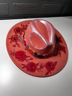 A hand-painted wide-brim hat with red floral designs, a metallic gradient crown, and an embroidered floral hatband for a bold, elegant look. Decorating Cowboy Hats, Pink Cowboy Hat, Pink Cowboy, Cowgirl Hat, Flower Hats, Cowgirl Hats, Wide Brimmed Hats, Hat Band, Brim Hat