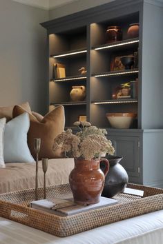 a vase with flowers on a tray in the middle of a living room