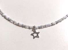 This dainty Seed Bead Star Choker Necklace is made with pretty multicolored glass seed beads. The tiny seed beads are strung on beading wire & finished with a stainless steel lobster style clasp with a 2 inch extension chain, to allow for personal size adjustments. These necklaces are perfect for everyday wear. Enjoy a simple, minimalist look with a single strand or layer them with some of our other chokers. * Custom hand-made to order * Glass seed bead size 11/0 * Lobster Clasp closure * St Tiny Beaded Necklaces, Seed Bead Necklace With Charm, Simple Beaded Necklace Ideas, Adjustable Star-shaped Beaded Chain Necklace, Silver Beaded Bracelet With Star Charm And Round Beads, Silver Beaded Bracelets With Star Charm, Adjustable Star-shaped Necklace With Colorful Beads, Silver Necklaces With Star Charm And Round Beads, Silver Necklace With Star Charm And Round Beads