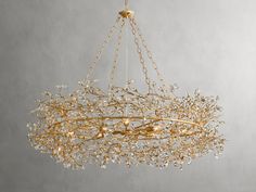 a gold chandelier hanging from the ceiling with white flowers and leaves on it