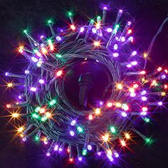 an assortment of multicolored christmas lights on a black background with space for text