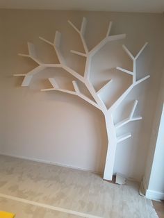 an empty room with a white tree on the wall