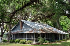 an old house is surrounded by trees and grass