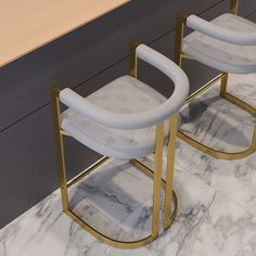 two white chairs sitting on top of a marble floor next to each other in front of a counter