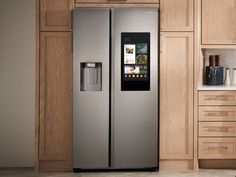 a silver refrigerator freezer sitting inside of a kitchen next to wooden cupboards and drawers