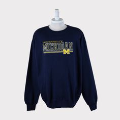 Embroidered Vintage 90s Michigan Wolverines (University of Michigan) Football/Baseball/Basketball/Hockey NCAA Sweatshirt 💯 SATISFACTION AND AUTHENTICITY ⭐ MEASUREMENTS (when laid flat) Size on Tag: XL (fit 2XL) Length: 80cm or 31.5 inches Armpit to armpit: 67cm or 26.5 inches ⭐ CONDITION 9/10 (Very good) Details: No holes Material: Cotton Color: Dark Blue Navy Brand: Majestic 🔷 Please give us your phone no. together with address after you purchased. 🔷Please keep in mind that our items are vin University Michigan, Wolverine Shirt, Michigan University, Football Sweater, West Virginia University, Michigan Football, West Virginia Mountaineer, University Of Virginia, Football And Basketball