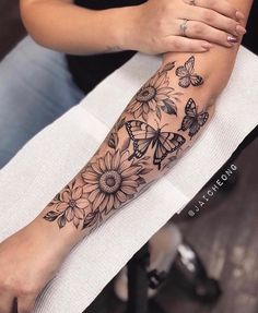 a woman's arm with sunflowers and butterflies on it