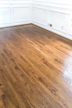 an empty room with hard wood flooring and white paneled walls on the wall