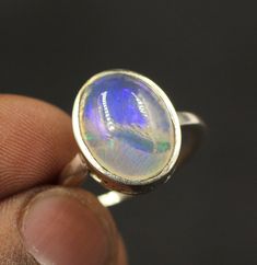 Ethiopian Opal Ring, Sterling Silver Rings, Boho Simple Ring with Big Stone, Birthstone Gemstone Ring  Name of Gemstone : Ethiopian Opal Weight : 4 Gram Stone size : 10x14mm Metal : 925 Sterling Silver Opal Stone Properties : Ethiopian opal is believed to be an emotional intensifier, enhancing the true nature of those who wear it. Some say it strengthens the will to live and shields the wearer against negativity, burning off karma. Practitioners of energy work say it activates the base and sacra Sterling Silver Rings Boho, Will To Live, Ring Name, Stone Properties, Rings Boho, Names Of Gemstones, Ethiopian Opal Ring, Simple Ring, Energy Work