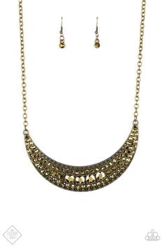 Varying in size, row after row of golden aurum rhinestones are encrusted along the front of a studded crescent moon brass frame, creating a glittery statement below the collar. Features an adjustable clasp closure. Sold as one individual necklace. Includes one pair of matching earrings. Gold Moon-shaped Metal Jewelry, Crescent Moon Phase Jewelry For Party, Gold Semi-circle Brass Jewelry, Metal Moon Phase Jewelry For Parties, Gold Crescent Jewelry For Party, Semi-circle Gold Brass Jewelry, Gold Brass Semi-circle Jewelry, Gold Half Moon Shaped Metal Jewelry, Paparazzi Fashion