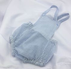 Ultimate hot weather unisex attire for Baby! Classic style summer sunsuit/romper. Lightweight cotton blue/white striped seersucker fabric is almost weightless while making Baby look VERY cool and put together! Machine wash and dry. Cotton material was pre-washed/dried so it will stay the same size you bought after washing/drying at home. SIZES: 3-6 mo, 6-12 mo Casual Blue Bubble Romper For Summer, Blue Summer Bubble Romper For The Beach, Blue Summer Bubble Romper For Beach, Summer Cotton Onesie, Fitted Cotton Onesie For Beach, Light Blue Cotton Jumpsuits And Rompers For Summer, Blue Bubble Romper For Summer, Light Blue Cotton Summer Jumpsuit, Fitted Beach Onesie For Summer