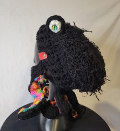 a crocheted hat on top of a mannequin's head with eyeballs