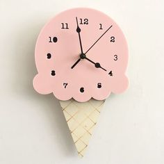 a pink clock with an ice cream cone on it's face and numbers in the middle