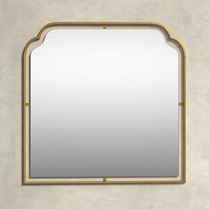 a mirror that is on the wall with a gold frame and an arched window above it